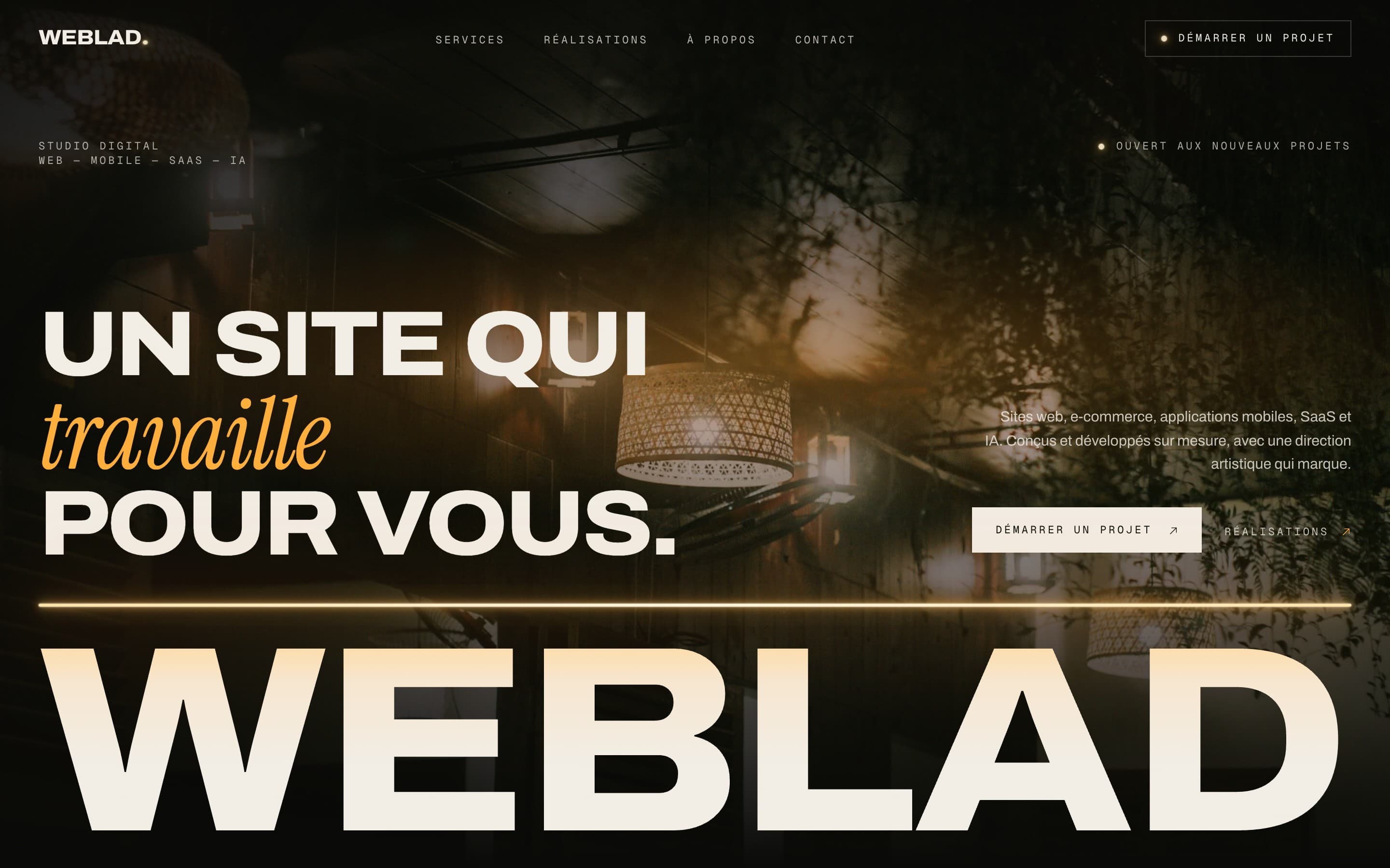 Page d'accueil du site WEBLAD : grand wordmark sous un néon ambre, devant une photographie de bois et de végétation